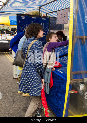 Deux jeunes filles shopping pour les bijoux à un étal de marché à Cristchurch, Dorset, Angleterre. Banque D'Images