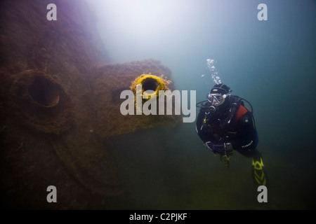 Un plongeur inspecte l'avant 4,1 pouces gun du destroyer allemand, F2 à Scapa Flow, Orkney Banque D'Images