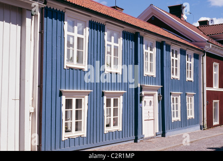 Rangée de maisons colorées (bleu, rouge) sur rue. Style traditionnel avec bardage bois, 18e ch. Vimmerby, Smaland. Banque D'Images