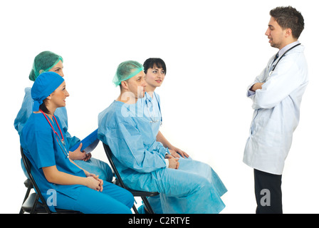 Jeune médecin homme ayant un discours à la conférence et d'autres quatre médecins différents lui écoute isolé sur fond blanc Banque D'Images