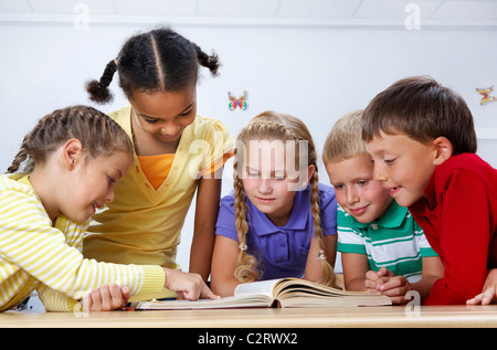 Portrait d'élèves de regarder la page de l'Encyclopédie canadienne au cours de la lecture Banque D'Images