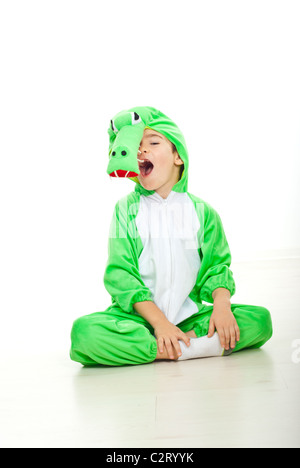 Funny boy habillés en costume de crocodile assis au sol avec les jambes croisées et grande gueule open i Banque D'Images