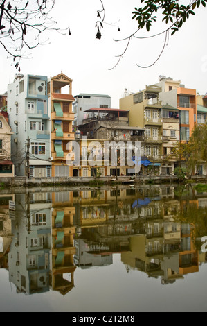 Vue verticale de tall thin maisons qui se reflètent dans un lac dans une banlieue de Hanoi central. Banque D'Images