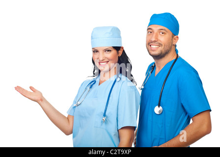 Deux chirurgiens joyeuse avec la main ouverte en signe de bienvenue ou de faire une présentation de copie espace isolé sur fond blanc Banque D'Images
