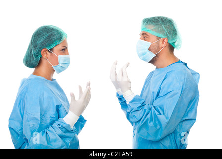 Deux médecins en uniforme stérile debout face à face, tenant les mains dans des gants de protection et avoir une conversation Banque D'Images