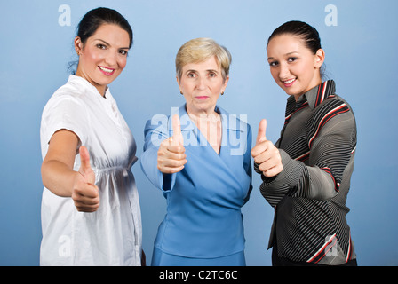 Trois jeunes et senior femme,giving Thumbs up and smiling isolé sur fond bleu Banque D'Images