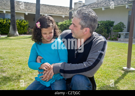 Un enfant de cinq ans Egyptian-American fille grimace de douleur d'un estomac à l'extérieur dans Laguna Niguel, CA. Banque D'Images