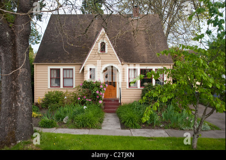 Bungalow en bois ancienne entourée d'arbustes verts Banque D'Images
