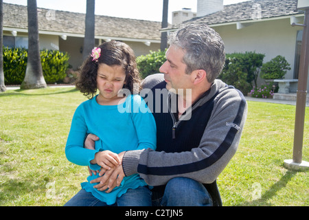 Un enfant de cinq ans Egyptian-American fille grimace de douleur d'un estomac à l'extérieur dans Laguna Niguel, CA. Banque D'Images