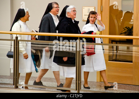 Quatre personnes âgées des religieuses catholiques à pied grâce à un immeuble de bureaux de San Francisco en pleine habitude. Banque D'Images