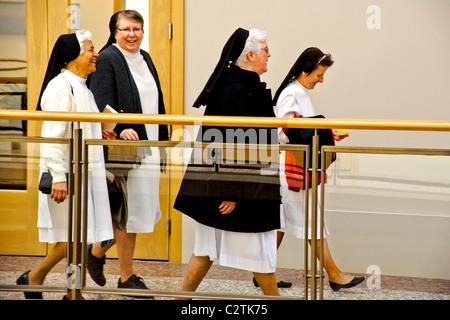 Quatre personnes âgées des religieuses catholiques à pied grâce à un immeuble de bureaux de San Francisco en pleine habitude. Banque D'Images