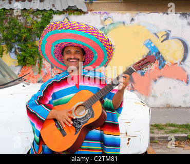 L'humour mexicain woman playing guitar poncho sombrero dans Street Banque D'Images