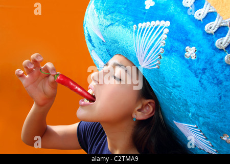 Mexican girl eating profil red hot chili pepper Mexican Hat Banque D'Images