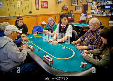 Les joueurs de différents âges et courses jouer au Texas Hold'em poker dans un magasin/casino à Merced, Californie. Banque D'Images