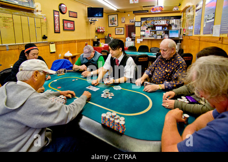 Les joueurs de différents âges et courses jouer au Texas Hold'em poker dans un magasin/casino à Merced, Californie. Banque D'Images