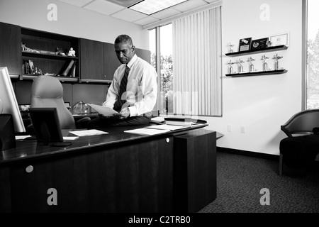 African American businessman sitting on desk Banque D'Images