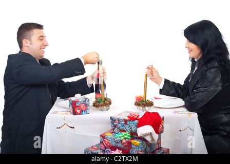 Heureux mari ouverture bouteille de champagne et la préparation pour pain grillé avec sa femme à la table de Noël Banque D'Images