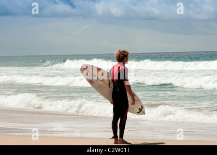 Surfer regardant le surf sur la plage, El Cotillo, Fuerteventura, Îles Canaries Banque D'Images