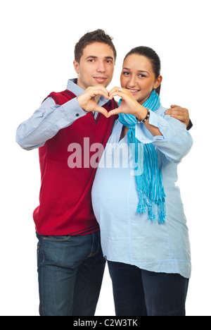 Couple avec femme enceinte formant un cœur avec leurs mains pour montrer l'amour isolé sur fond blanc Banque D'Images