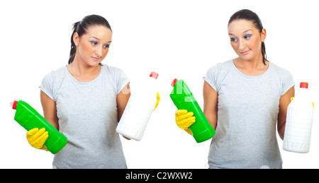 Femme avec grimace sur le visage essayant de choix de deux produits de nettoyage isolé sur fond blanc Banque D'Images