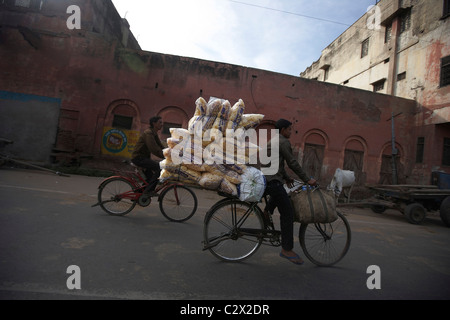 Man on bicycle avec charge lourde. Scène de rue d'Agra, Uttar Pradesh, Inde, sous-continent indien, en Asie. Banque D'Images