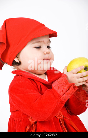 Petite fille en profil semi tenant une pomme verte et à la recherche à la fruit Banque D'Images