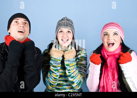 Trois amis heureux dans des vêtements d'hiver et d'encouragement de la recherche des surpris .Vous pouvez ajouter dans cette image,cadeaux cadeaux, argent Banque D'Images