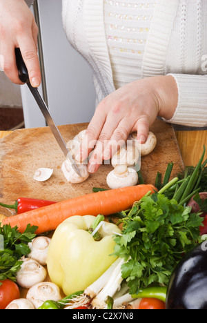 Femme en découpage sur bois cuisine champignons conseil et variété de légumes frais Banque D'Images