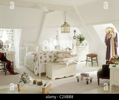 Lit double en fer forgé blanc avec motif floral couvrir dans une chambre mansardée Banque D'Images