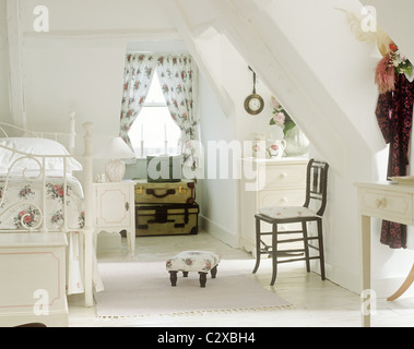 Lit double en fer forgé blanc avec motif floral couvrir dans une chambre mansardée Banque D'Images