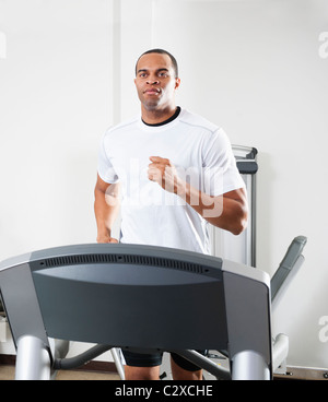 Mixed Race man running on treadmill Banque D'Images