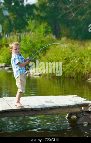 Photo de petit enfant tige de traction tandis que le week-end de pêche Banque D'Images