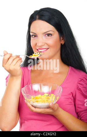 Belle femme de manger des Cornflakes céréales avec du lait d'un bol en verre isolé sur fond blanc Banque D'Images