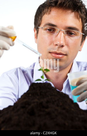 Chercheur travaillant dans un laboratoire ,il holding pipette et pot avec produits chimiques bleu Banque D'Images