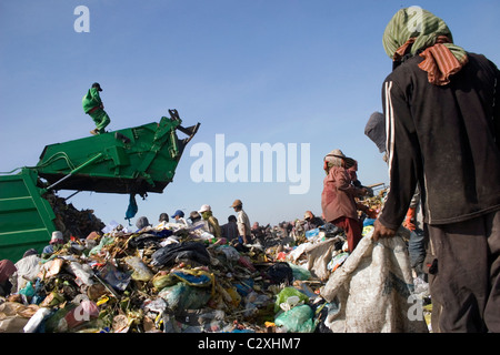 Un travailleur est de marcher sur le toit d'un camion à ordures à un dépotoir toxique et polluée au Cambodge. Banque D'Images