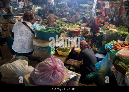 Une femme vendeur de légumes se prépare pour l'alimentation à l'intérieur du marché russe shopping à Phnom Penh, Cambodge. Banque D'Images