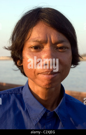 Une femme qui vit dans la pauvreté et confiné à un fauteuil roulant est relaxant près du fleuve Mékong à Phnom Penh, Cambodge. Banque D'Images