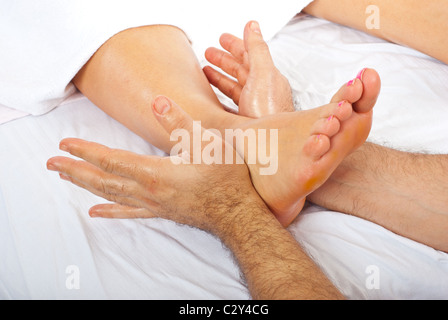 Détail de man's hands massaging woman's foot à spa resort Banque D'Images