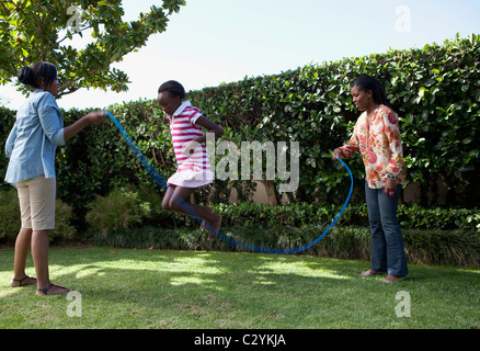 Corde à sauter enfants jouant dans le jardin, Johannesburg, Afrique du Sud Banque D'Images