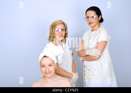 Jeune femme patient devant droit avec deux femmes plastic surgeon standing croisés et smiling Banque D'Images