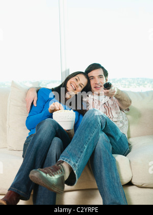 Couple eating popcorn and watching television Banque D'Images