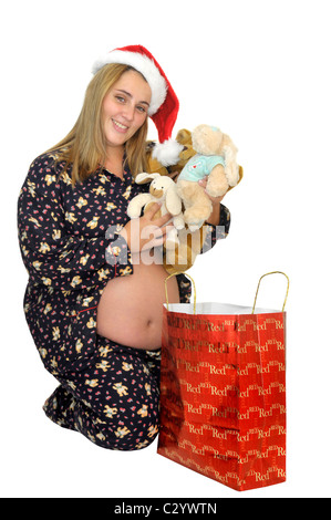 Belle fille enceinte en pyjama avec Santa's hat Banque D'Images