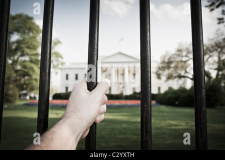 Une main agrippant la clôture à l'extérieur de la Maison Blanche à Washington, DC, USA. Banque D'Images