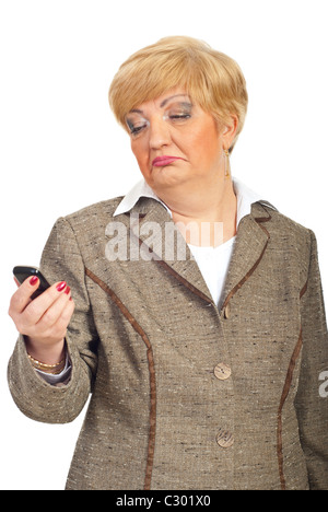 Femme mature semble de travers et surpris d'un téléphone cellulaire dans sa main isolé sur fond blanc Banque D'Images