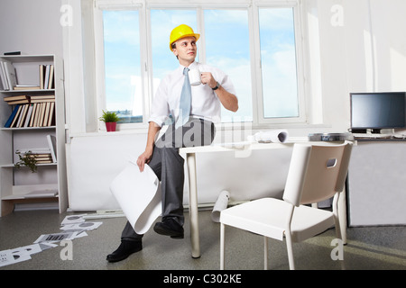 Portrait de l'architecte à boire du thé en fonction du casque Banque D'Images