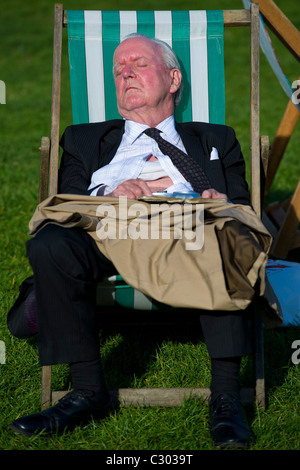 Les gens, les touristes et les employés de bureau, passer une après-midi ensoleillée dans transats dans Green Park, Londres. Banque D'Images