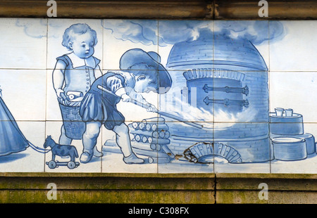 Delft, Pays-Bas. Delft bleu et blanc à carreaux de céramique au-dessus des passants dans Markt (place principale) Enfants four de la poterie de travail Banque D'Images