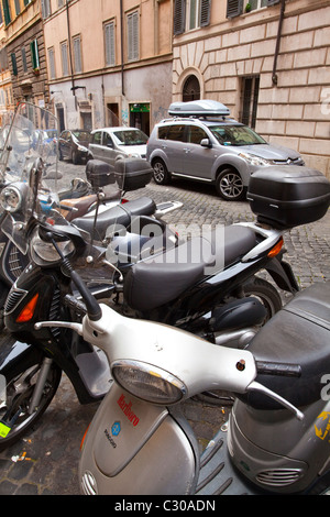 L'Italie, Lazio, Rome. Cyclomoteurs et scooters garés devant un restaurant typique de Rome dans la ville de Rome. Banque D'Images