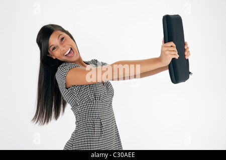 Pretty Young Asian woman laughs en maintenant un ordinateur portable sur un fond blanc. Plan horizontal. Banque D'Images