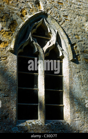 Fenêtre ancienne en pierre de style normand au 11ème siècle, l'église St Nicholas, près de Oddington Stow on the Wold, Gloucestershire Banque D'Images